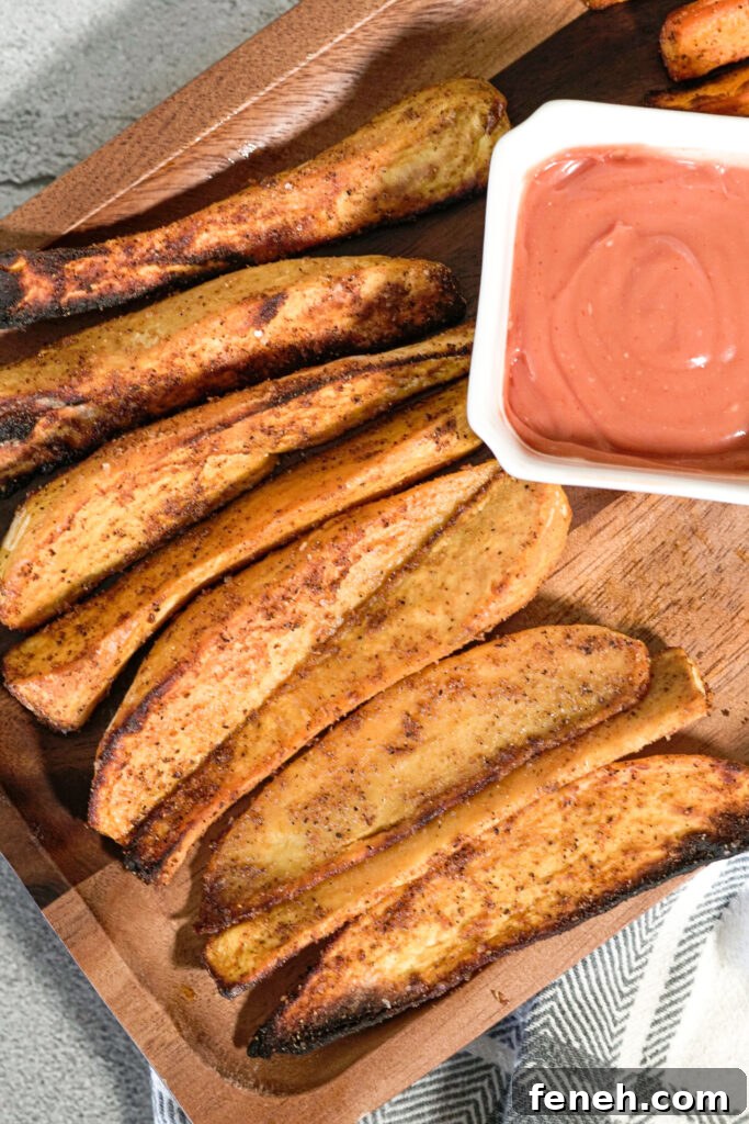 crispy air fried sweet potatoes on a wooden serving platter with dipping sauce