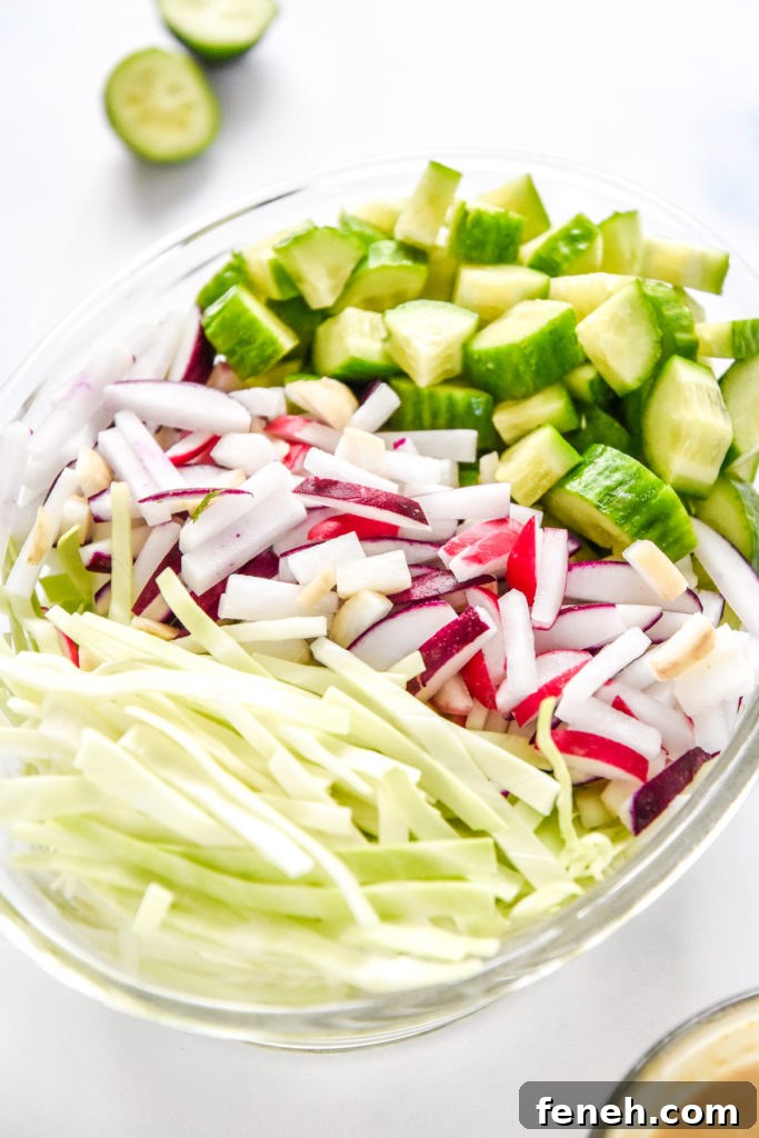 cut radish, cabbage and cucumbers in a glass bowl.