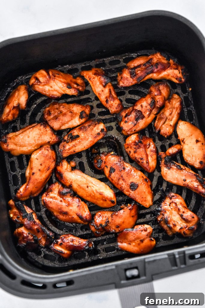 air fryer honey sriracha chicken in the air fryer basket.
