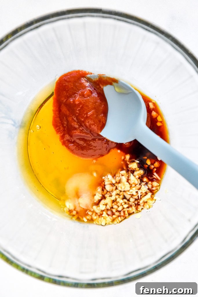 honey, sriracha, garlic and soy sauce in a glass bowl before stirring.