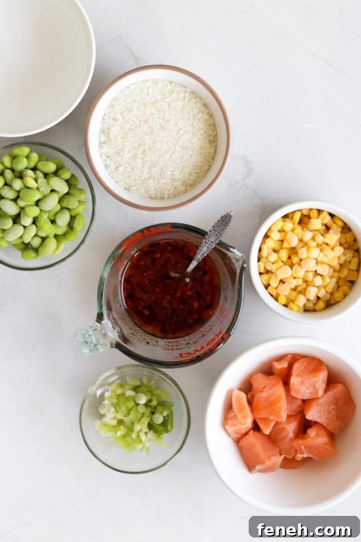 Ingredients for salmon rice bowl displayed in small white bowls on a white marble kitchen counter