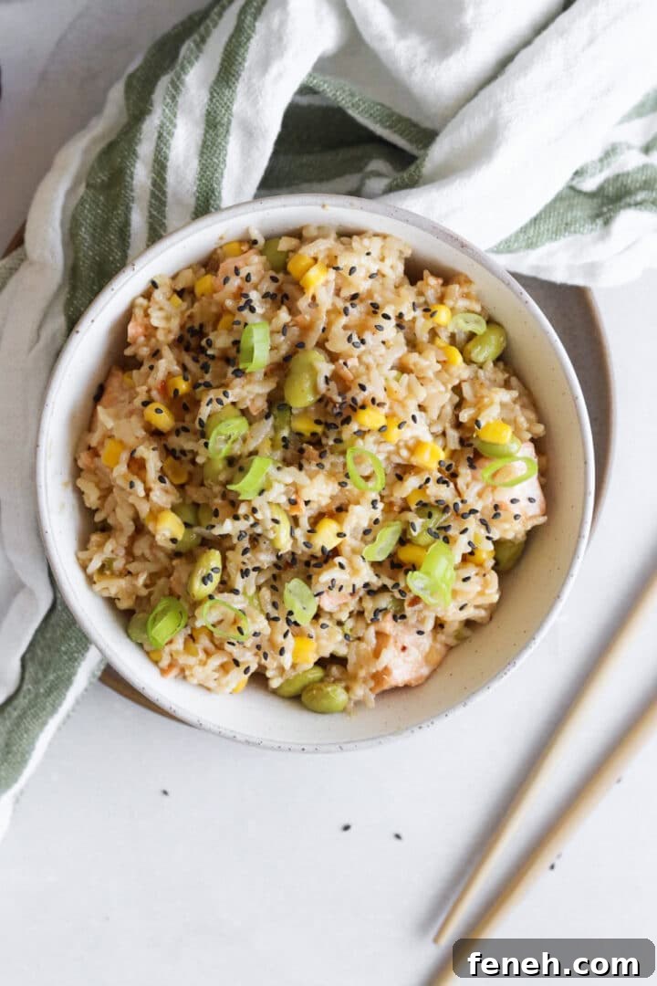 Birdseye photo of a white bowl containing a one pot salmon rice cooker dish