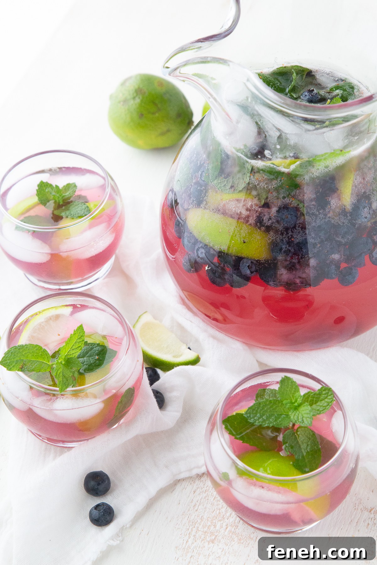 pitcher and glasses filled with blueberry mojitos