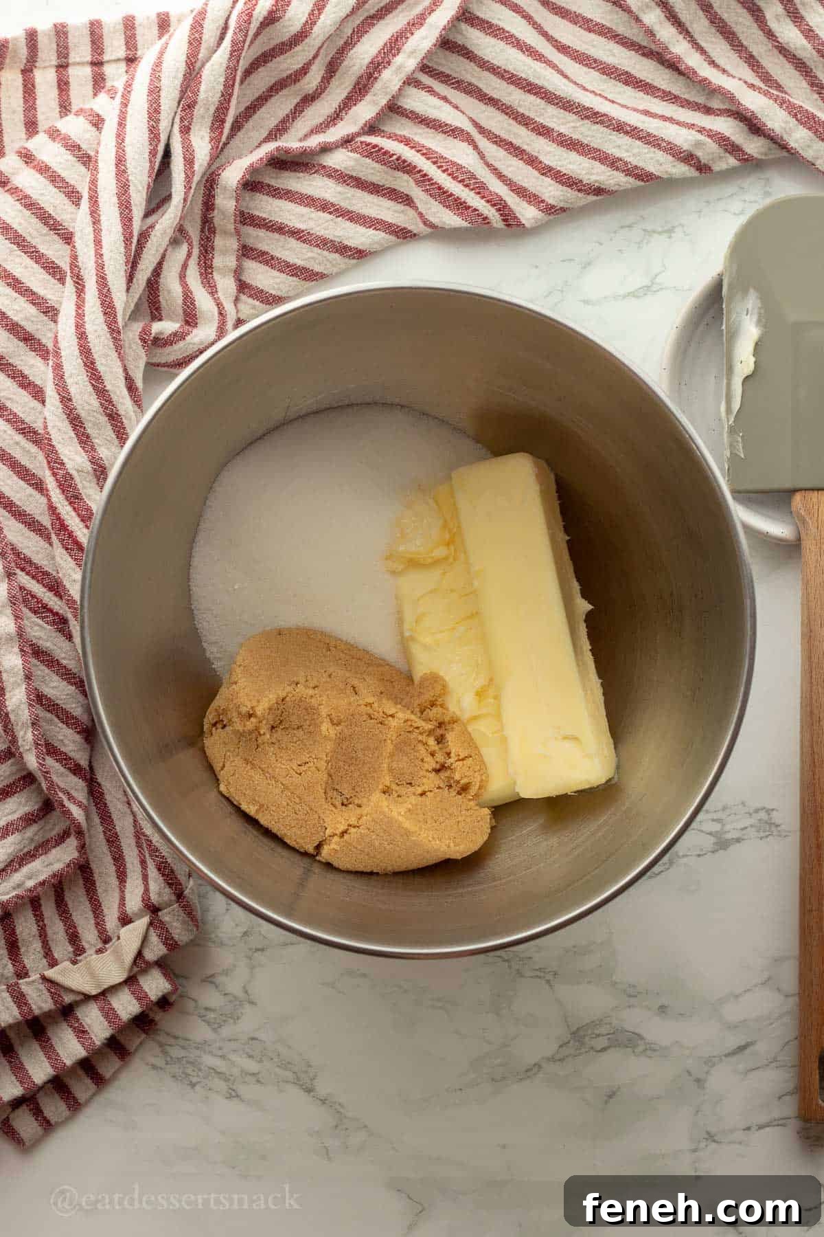 Butter and sugars in metal mixing bowl.