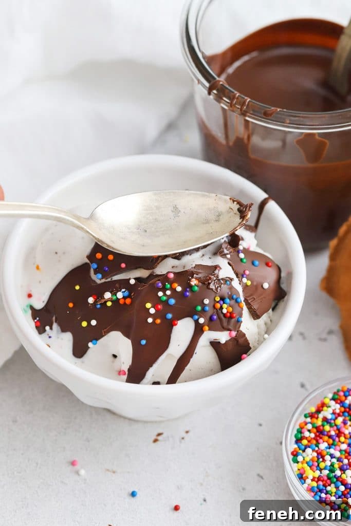 Cracking the homemade magic chocolate shell on a scoop of vanilla ice cream with a spoon