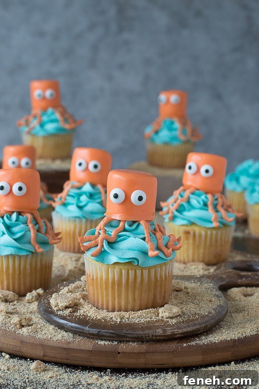 Seven orange and blue Octopus Cupcakes on a wooden board.