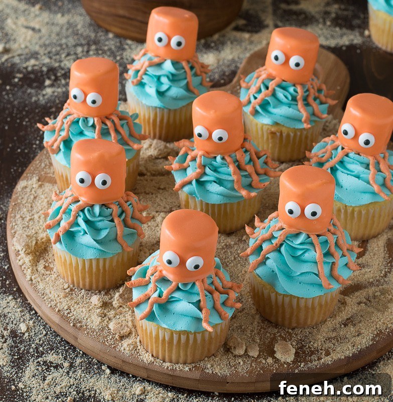 Eight easy Octopus Cupcakes covered in blue buttercream frosting arranged on a round wooden board.